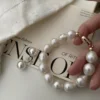 lose-up view of a Baroque pearl bracelet featuring large mother-of-pearl beads and a gold-plated clasp.