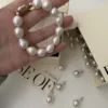 Baroque Pearl Bracelet Worn by Model - Gold-Plated Mother-of-Pearl Bracelet A model wearing a Baroque pearl bracelet with large mother-of-pearl beads, styled with a gold-plated clasp.