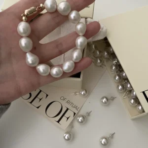 A model wearing a Baroque pearl bracelet with large mother-of-pearl beads, styled with a gold-plated clasp.