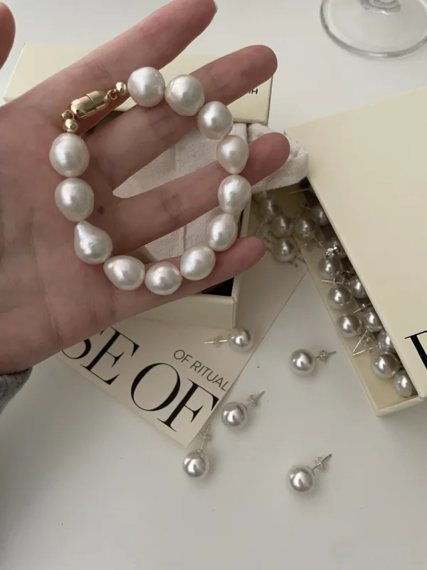Baroque Pearl Bracelet Worn by Model - Gold-Plated Mother-of-Pearl Bracelet A model wearing a Baroque pearl bracelet with large mother-of-pearl beads, styled with a gold-plated clasp.