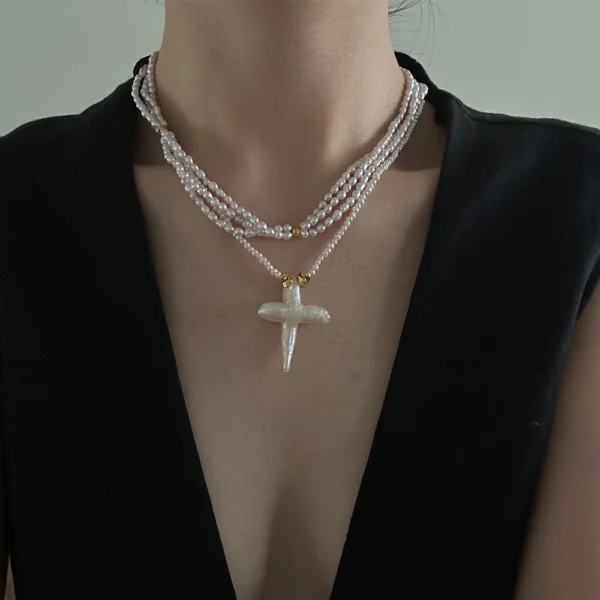 baroque pearl necklace with cross pendant layered on neck