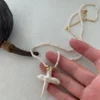 baroque pearl necklace cross pendant held in hand