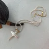 baroque pearl necklace with cross pendant on surface