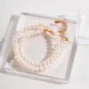 French natural pearl necklace with gold extender on acrylic block