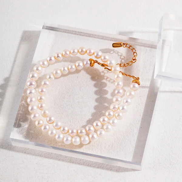 French natural pearl necklace with gold extender on acrylic block