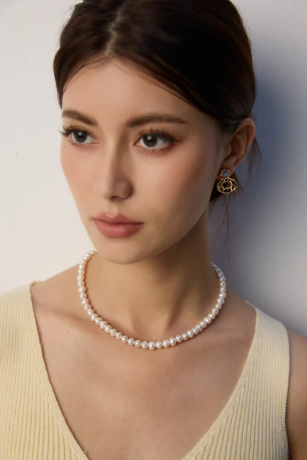 French natural pearl necklace close view at collarbone