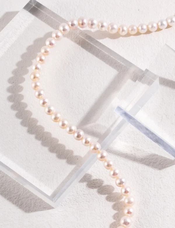 close-up strand of French natural pearl necklace on acrylic blocks
