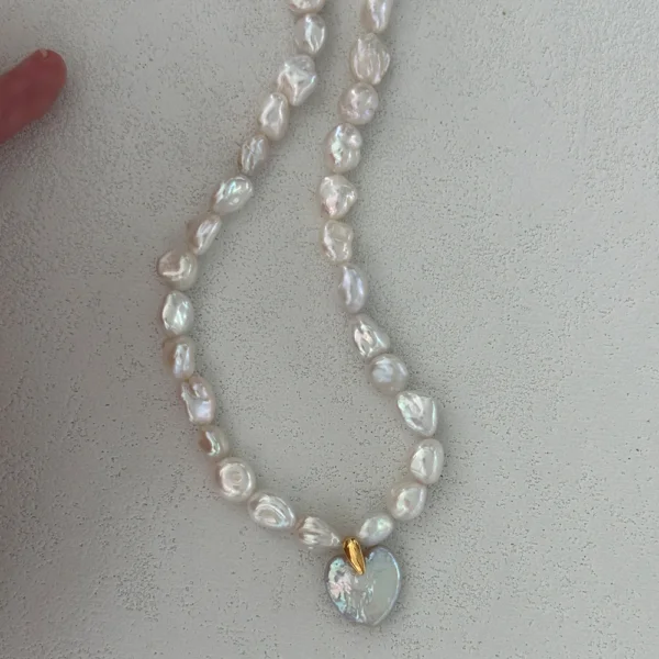 baroque pearl necklace with cross pendant layered on neck