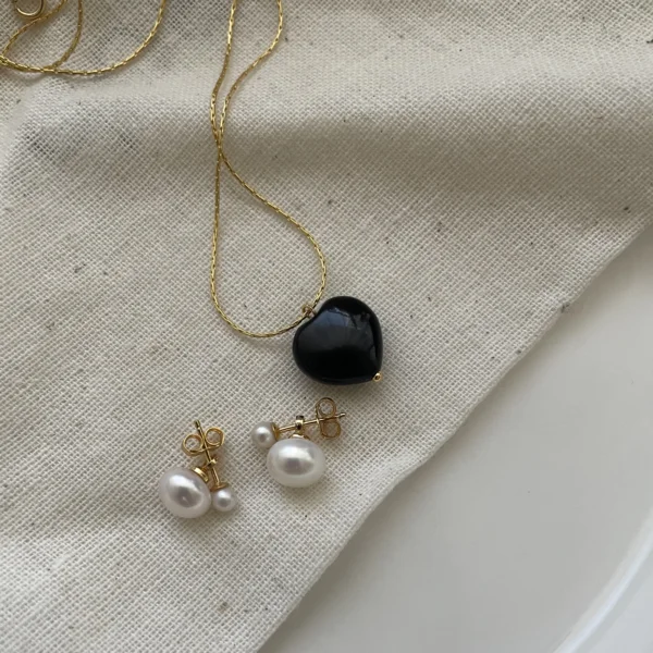 Minimalist freshwater pearl earrings styled with a delicate gold necklace