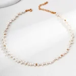 Model wearing Petal Rain Baroque Pearl Necklace in Vintage Gold