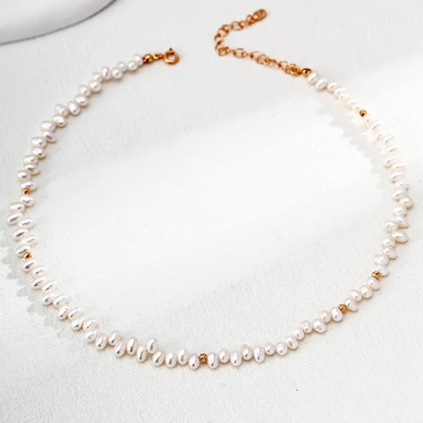 Model wearing Petal Rain Baroque Pearl Necklace in Vintage Gold