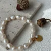 gold coin charm with small pearl on baroque pearl bracelet