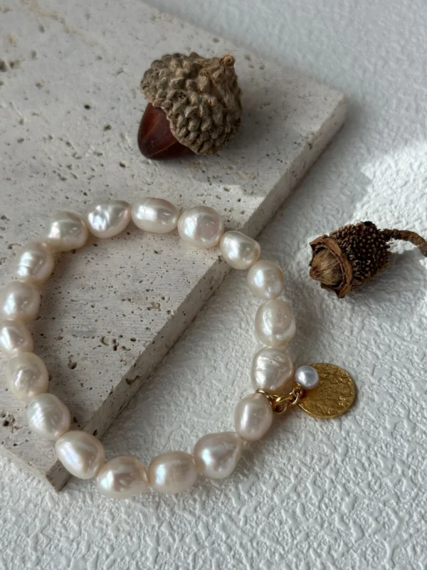 gold coin charm with small pearl on baroque pearl bracelet