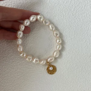 Baroque Pearl Bracelet – Coin Charm baroque freshwater pearl bracelet with gold coin charm held in hand