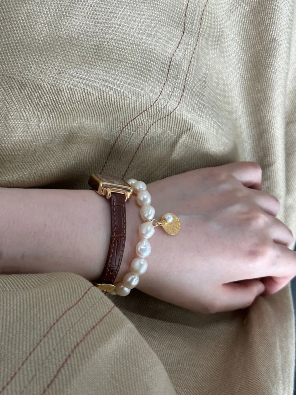 baroque freshwater pearl bracelet with gold coin charm on wrist