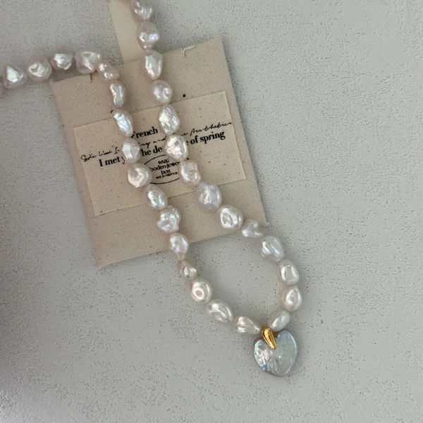 flat lay of heart-shaped baroque pearl necklace with pearl and shell beads