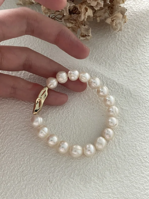 baroque freshwater pearl bracelet in hand for scale