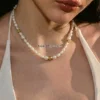 Natural baroque freshwater pearl necklace with a gold-tone toggle clasp, worn around the neck