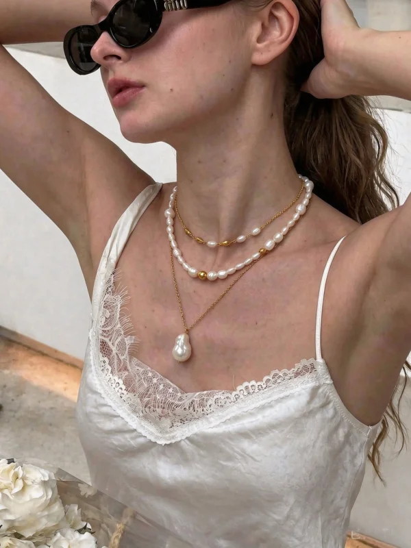 Close-up of a model wearing layered baroque freshwater pearl necklaces with gold-tone accents