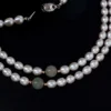 Close-up of a freshwater pearl necklace with jade accent beads and a 925-stamped clasp