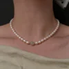 Close-up view of a white freshwater pearl necklace with a smooth jade center bead