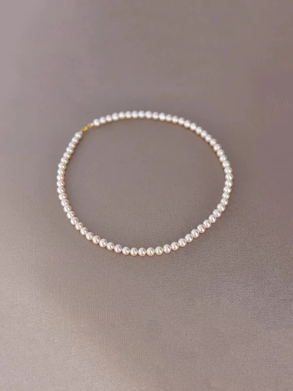 White Freshwater Pearl Necklace Flat Lay White 5.5–6mm near-round freshwater pearl necklace arranged in a circle